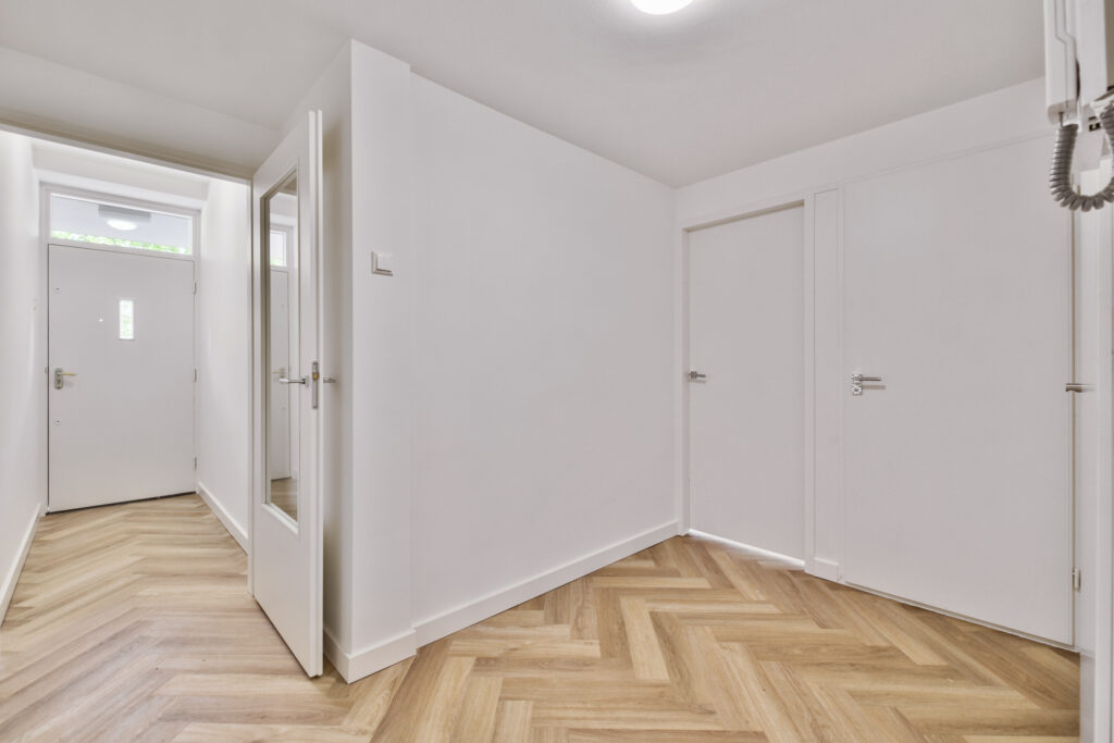 Empty interior area with white walls and laminate flooring