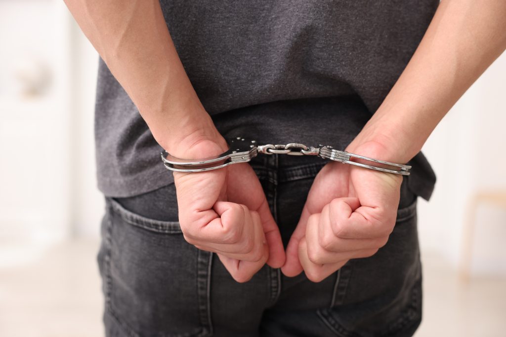 rear-view-of-a-man-in-handcuffs-standing-indoors-2026-05-07-20-12-01-utc-1024x683