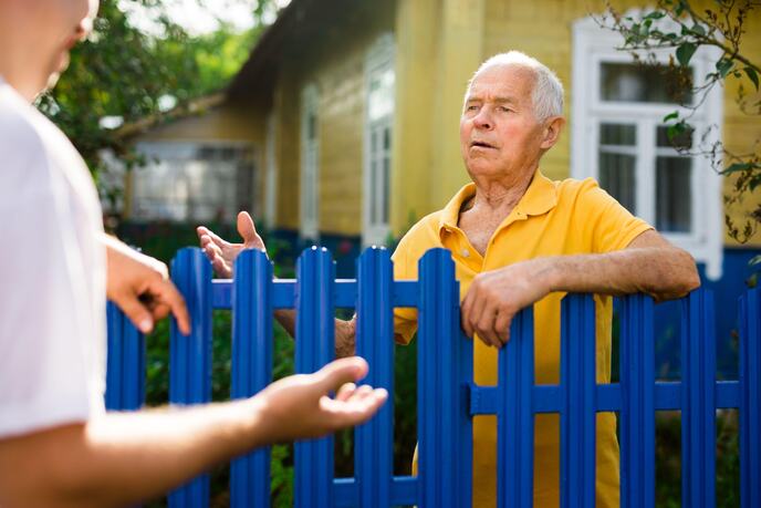 Good neighbors talk on border of their farms